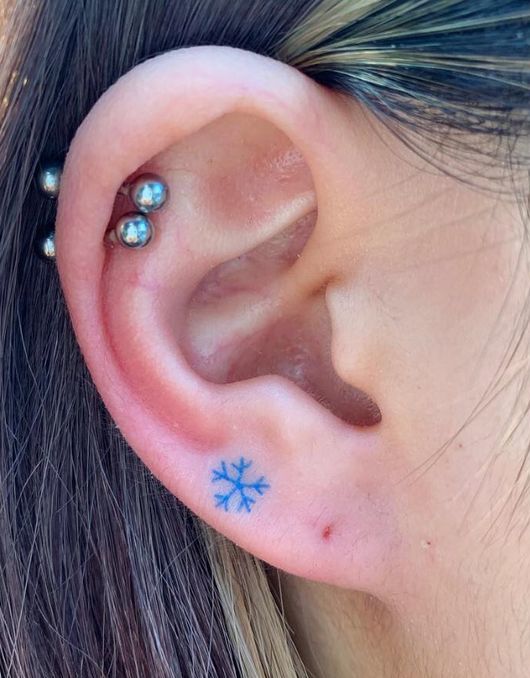 Snowflake Tattoo on pierced ear.