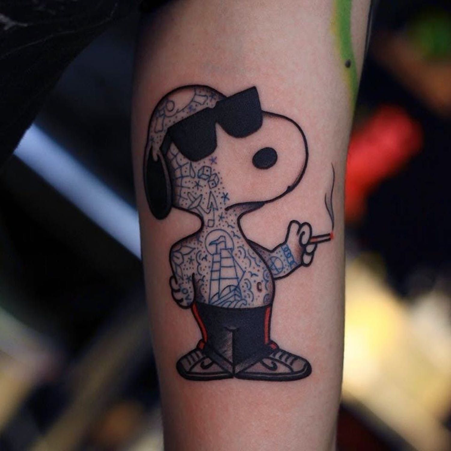 Minimalist Snoopy and Woodstock tattoo on the wrist