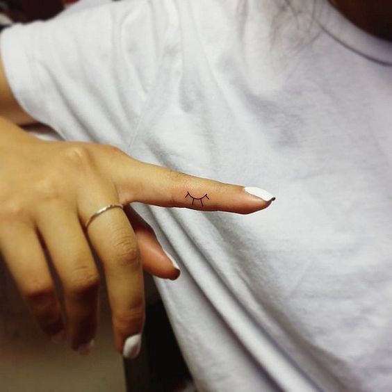 Small one eye lash tattoo on finger for women